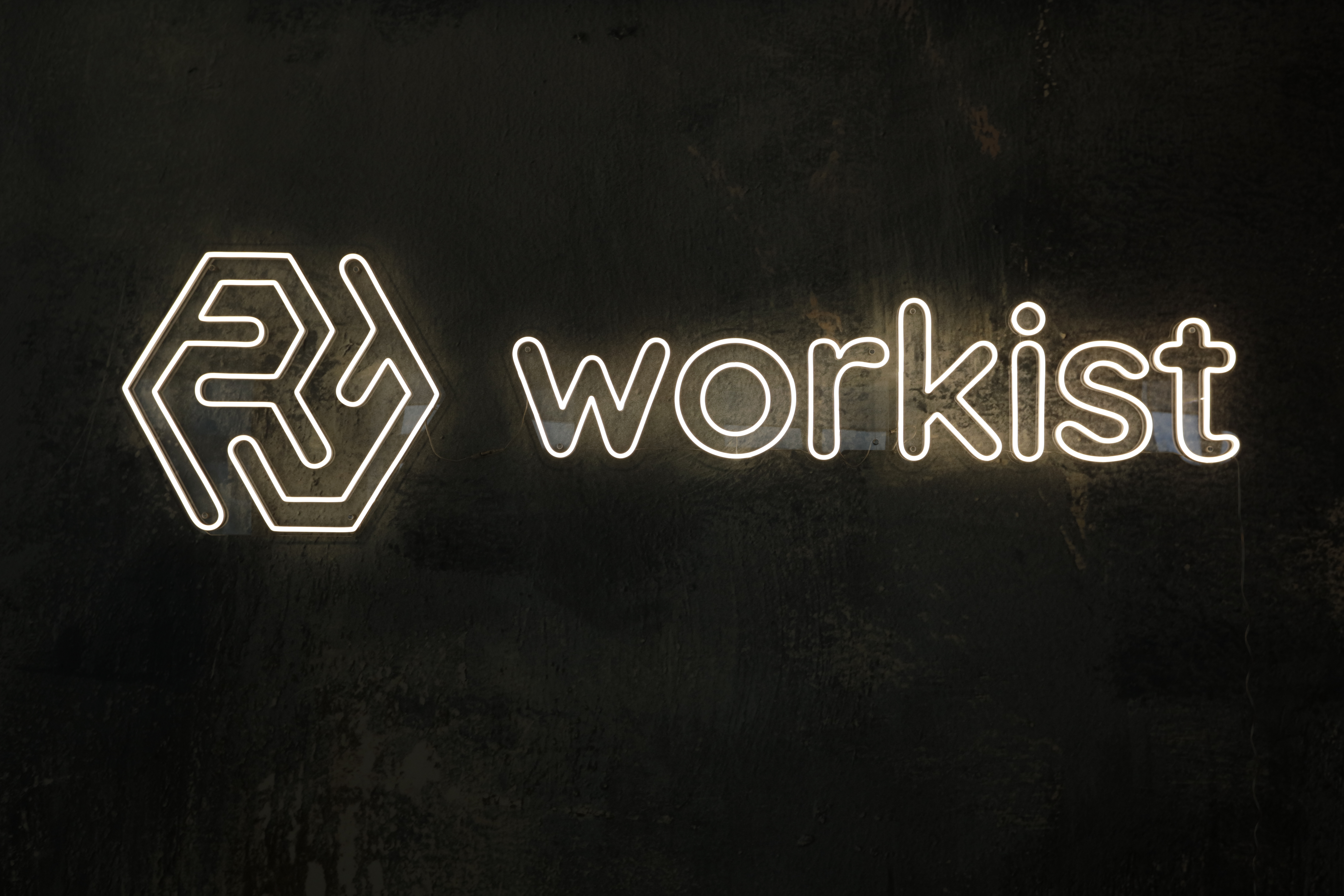 A glowing Sign of the Workist Logo